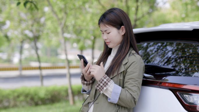 4K春天户外青年女性靠着汽车玩手机