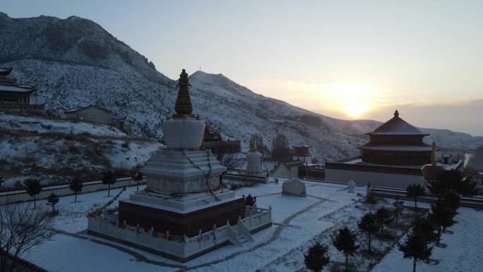 冬日被雪覆盖的佛塔落日美景4K航拍