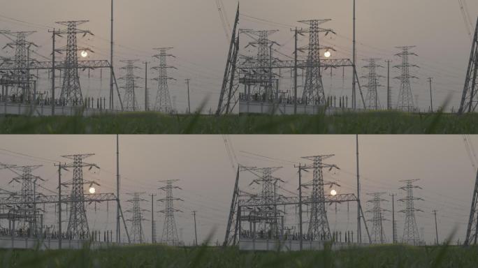 夕阳下骑车路过电站的人和狗