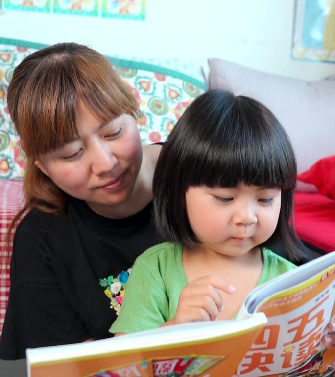 陪伴女儿阅读的年轻母亲