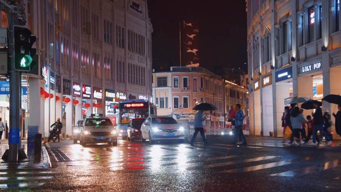 城市繁华街道雨天路口人群夜景