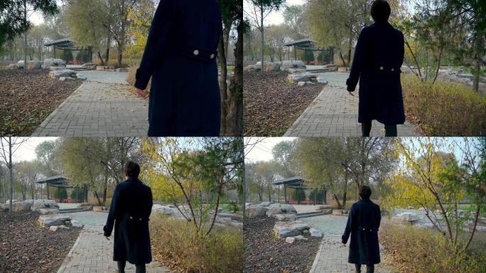 秋天独自走在公园小路上的中国女性
