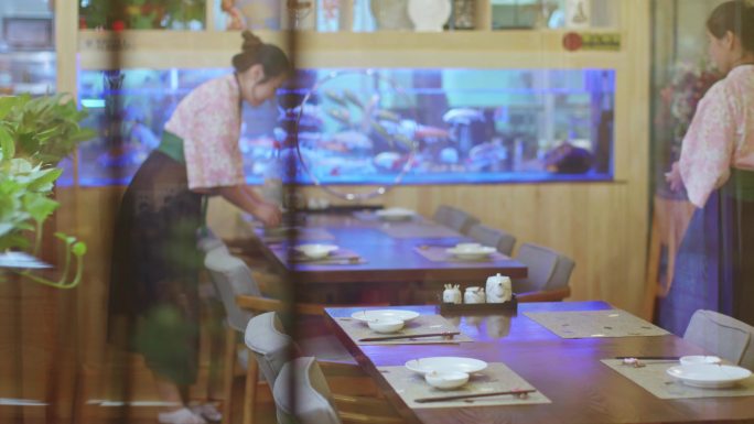 日本料理餐厅服务员在摆放餐具