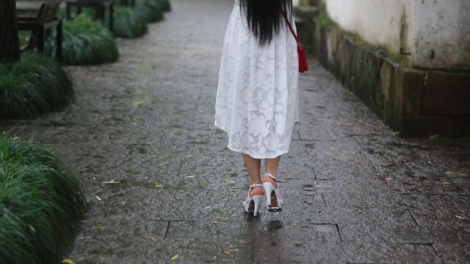 江南女孩白裙子红雨伞漫步青石板雨天背影
