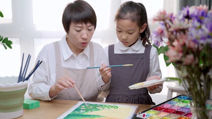 陪伴教导女儿绘画的中国母亲