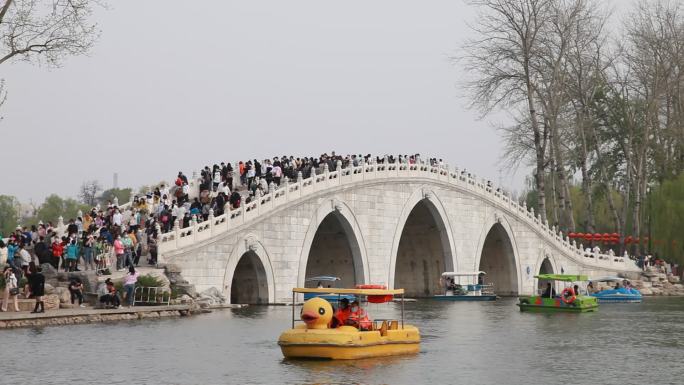 春季玉渊潭公园游人如织从桥上经过桥下过船