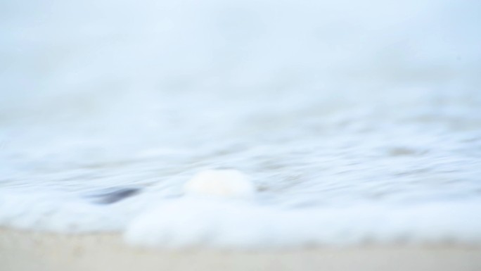 4K海浪拍打着沙滩上的贝壳