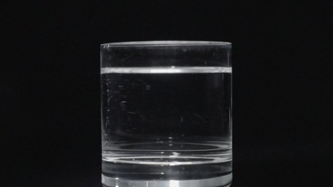 冰块落到水杯 拍摄 黑色背景