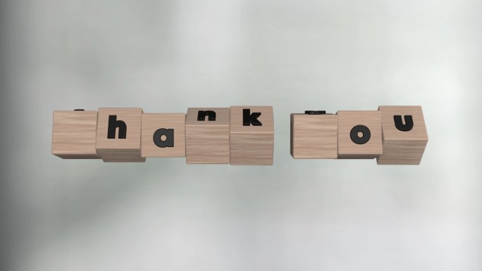 立方体上的字母组成了“谢谢”。前面是散焦的背景。
