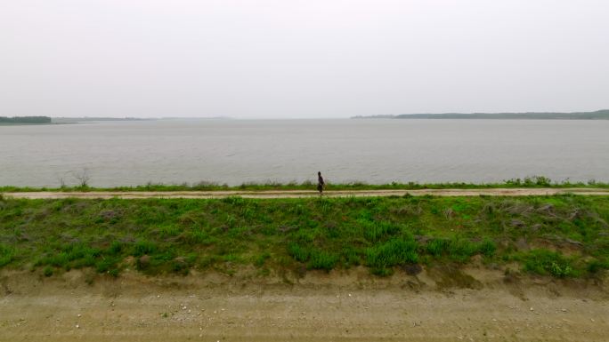 一位农村老人行走在梁子湖的湖中小路上航拍
