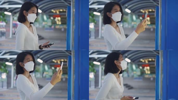 亚洲年轻女子在自动售货机上用手机付款