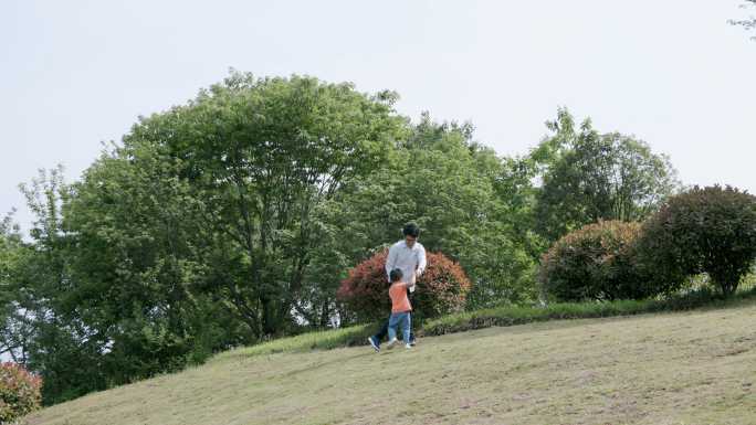 4K春天草地上爸爸和儿子玩耍