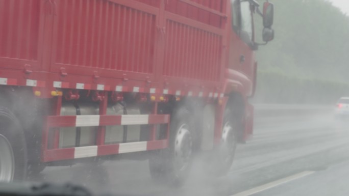 雨中大货车行驶在高速公路上飞溅水花慢镜头