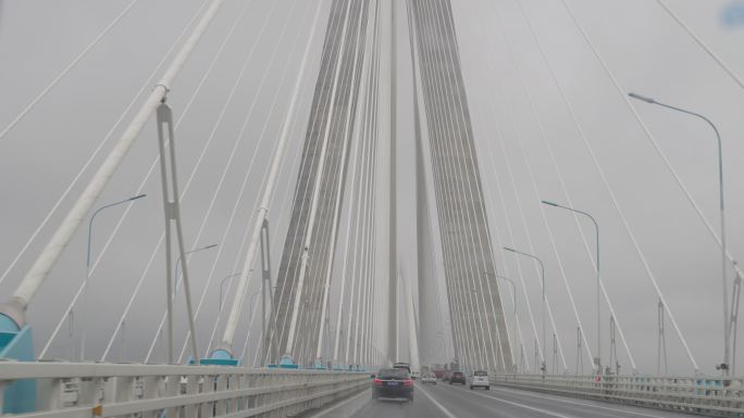 阴雨天车内升格拍摄驾车驶过苏沪通长江大桥