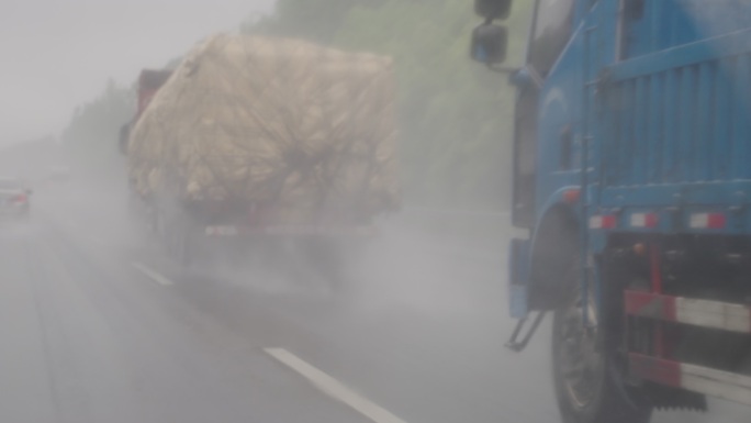 雨中大货车行驶在高速公路上飞溅水花慢镜头