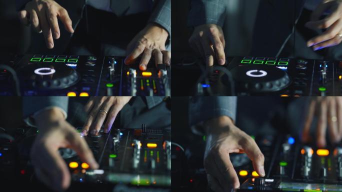 DJ的特写手在DJ混音台上调整各种音轨控制。