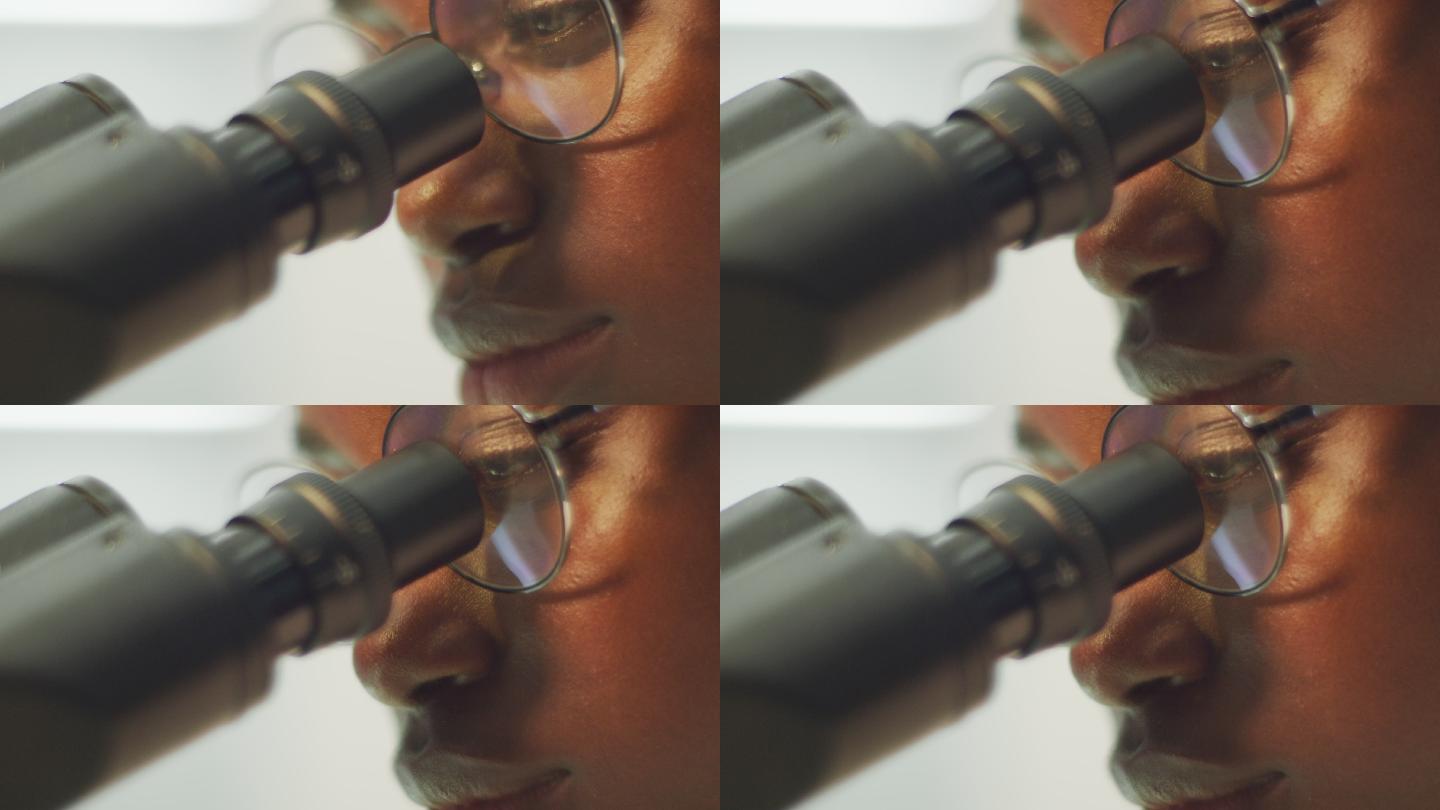 非洲裔女科学家，研究显微镜。面部特写