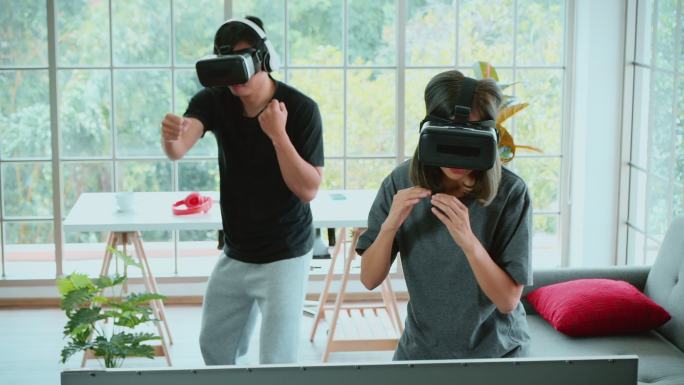 Metaverse，一对年轻夫妇在虚拟现实中玩游戏拳击，在家里进行踢腿训练。