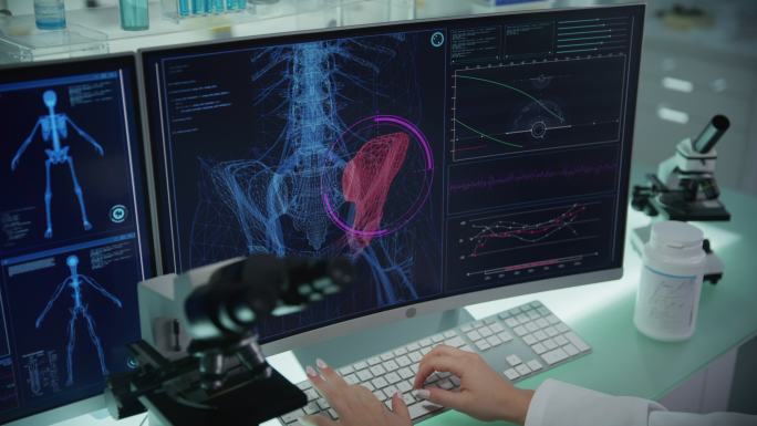 有计算机和显微镜的实验室。带有动画人体模型的屏幕。科学家扫描虚拟病人的受伤情况。臀部有红色斑纹。靠近