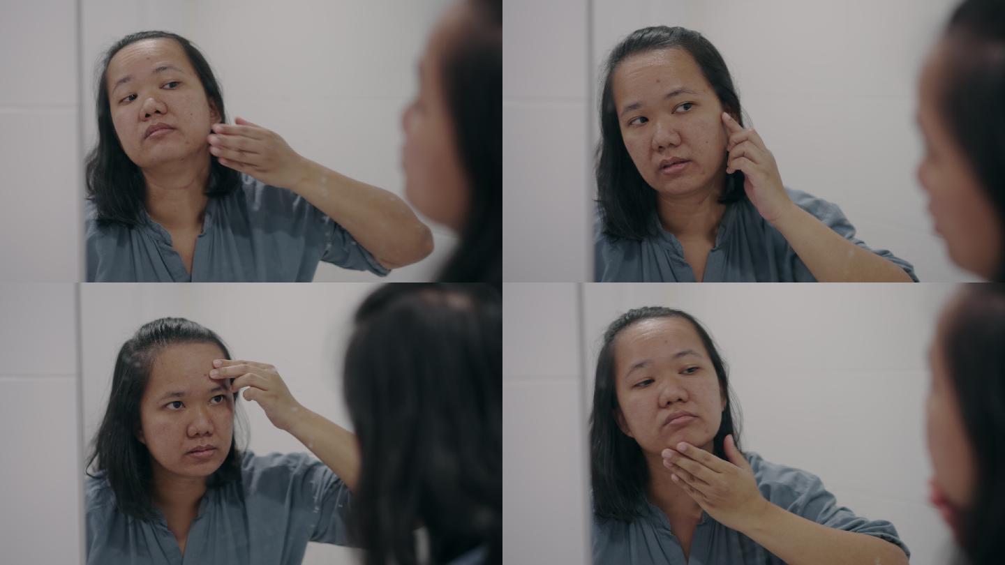 亚洲女人在浴室镜子里看自己的脸