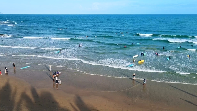 夏日海边冲浪人群海边游客海南旅游海滩海浪
