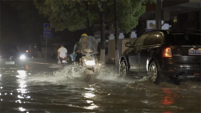 雨夜回家冒雨道路积水骑车回家城市雨夜安全