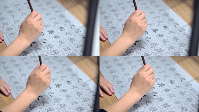 用字帖练习毛笔字的亚裔女性
