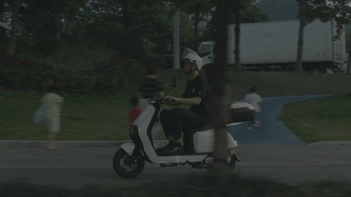 男子骑电动车在道路行驶