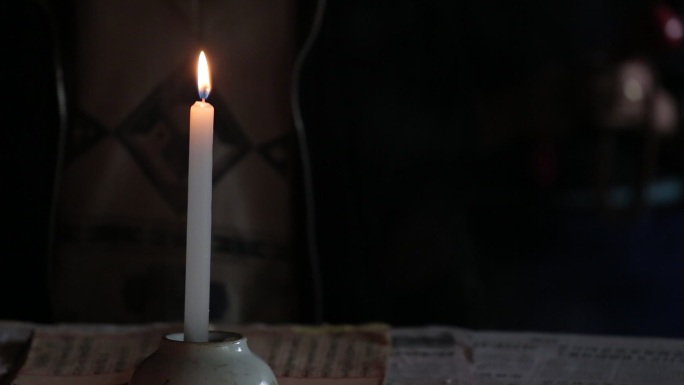 白族民众在点燃的蜡烛中吃斋念佛