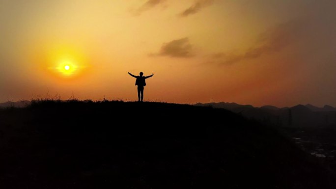 成功人士登山在山顶张开双臂拥抱未来