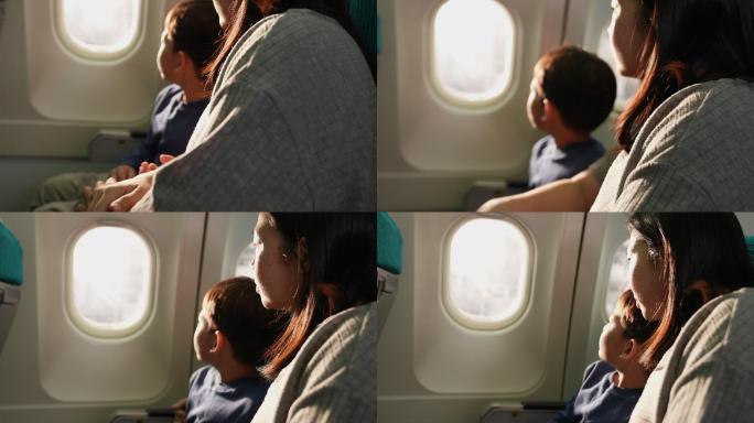 那男孩和他母亲坐在一起。商务飞机靠窗他看着窗户，兴奋地看着能坐飞机旅行。