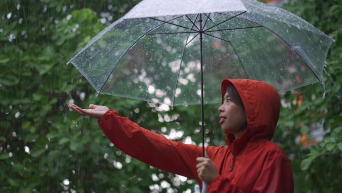 亚洲女人在户外下雨，她用雨伞。