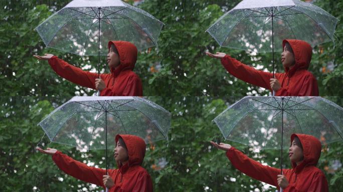 亚洲女人在户外下雨，她用雨伞。