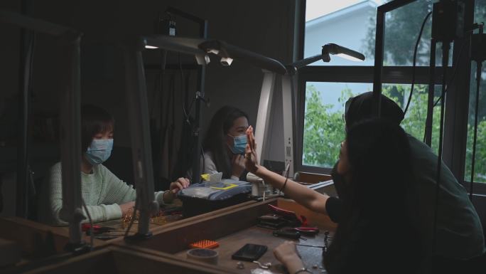 亚洲女大学生在workbench并肩打造珠宝设计