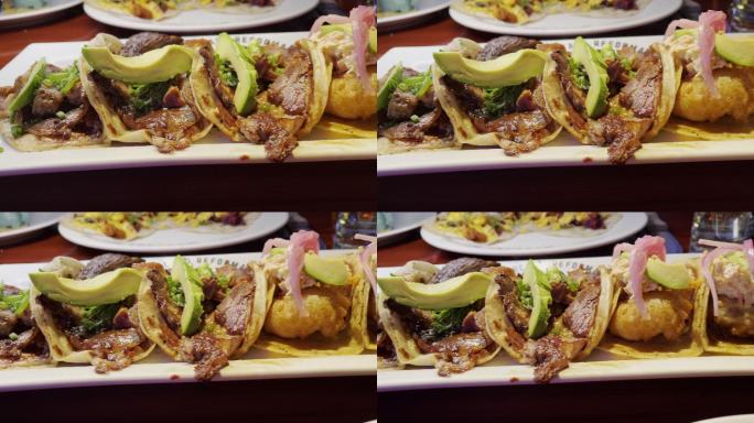 一个美食拼盘的视频剪辑，展示了两条切成薄片的上等肋骨和两个样式精美的鱼墨西哥卷