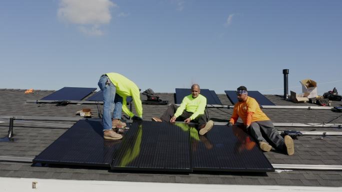 在加利福尼亚州住宅屋顶安装太阳能电池板的工人团队