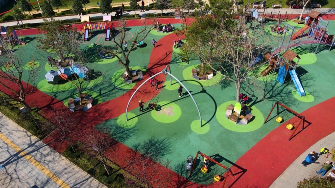 空中儿童游乐场，秋千和滑梯，快乐的孩子，在公园里玩耍的孩子和他们的家人，城市里的大公园