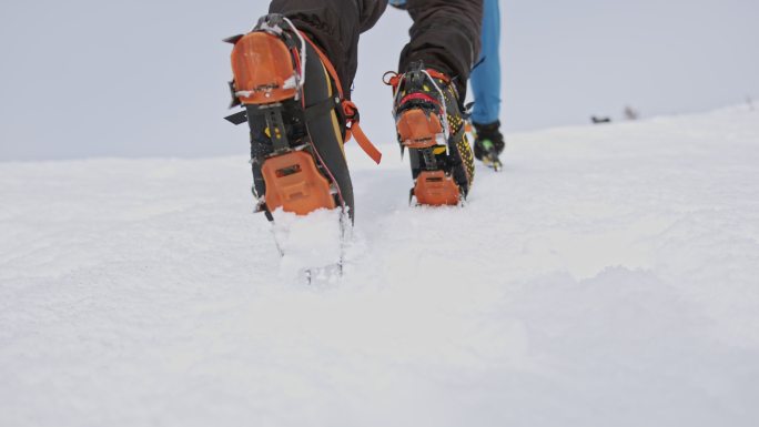 拿着冰斧爬雪山的登山者