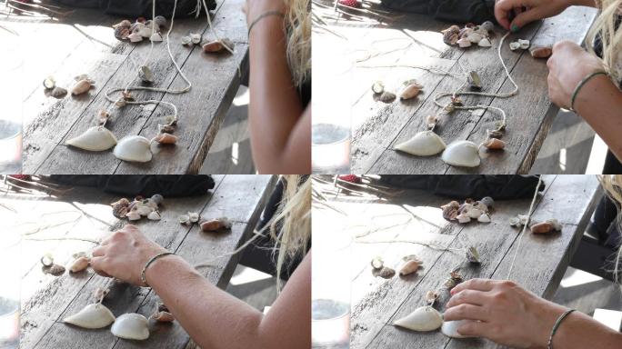 年轻女子用海滩贝壳制作风铃