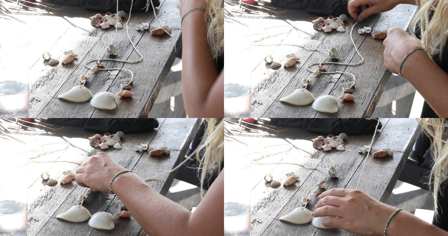 年轻女子用海滩贝壳制作风铃