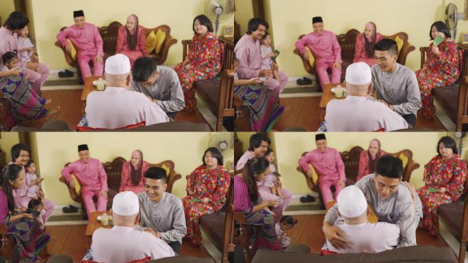 在艾迪尔菲特里庆典上，穿着传统服装的马来穆斯林孙子向祖父做道歉手势。马来家庭在家庆祝哈里拉亚节