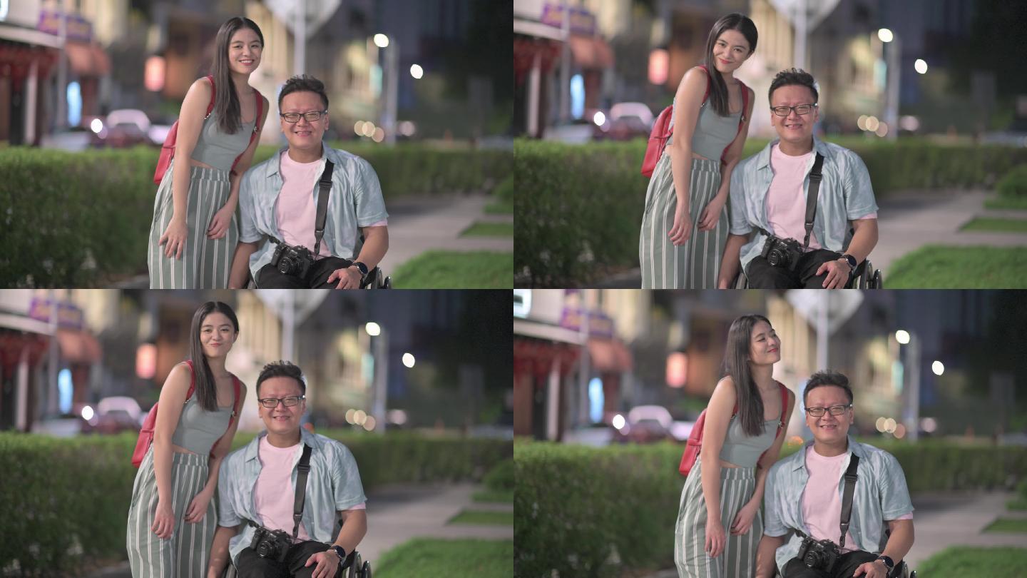 带着轮椅的亚裔中国游客和他的女朋友微笑着看着镜头