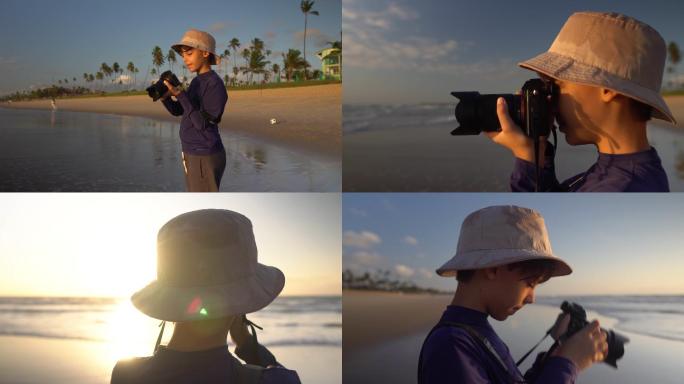 日出时在海滩上拍照的男孩