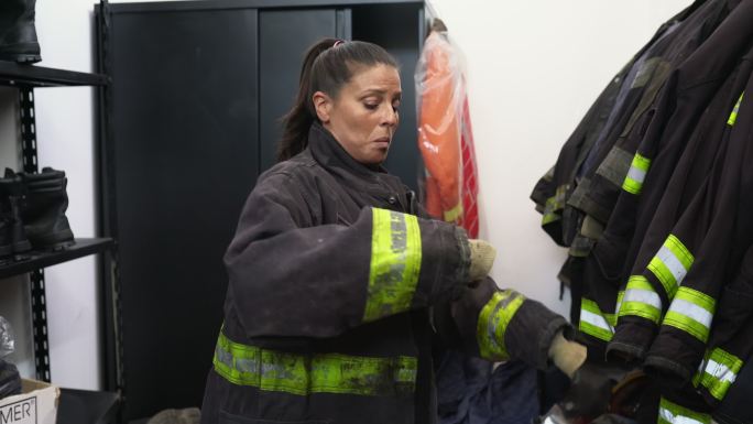 女消防员在装备室穿上救生衣