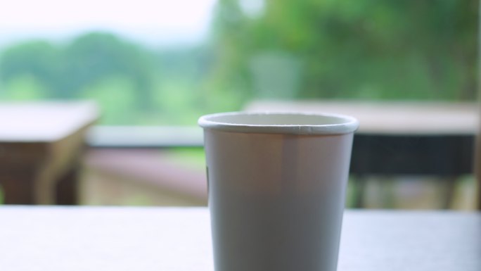 打开盖子的一次性杯子里有热咖啡的蒸汽