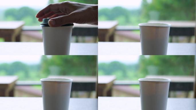 打开盖子的一次性杯子里有热咖啡的蒸汽