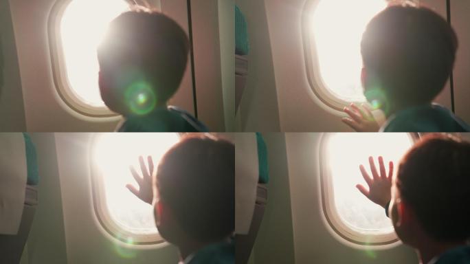 一个男孩坐在窗边的一架商用飞机上，他把手放在窗户上，兴奋得要飞了。从后面拿走。