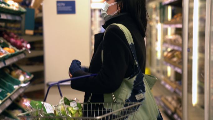 戴口罩的女人在超市买蔬菜和水果