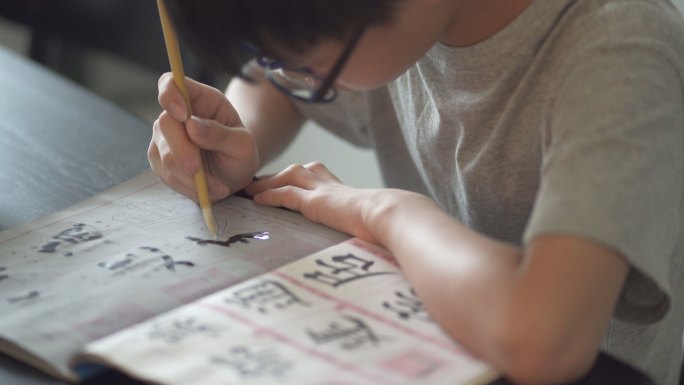 亚洲华人少年在家练习中国书法