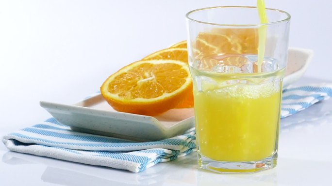 把橙汁倒进杯子里橘子汁素材